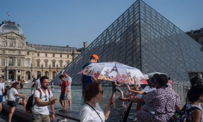 Photo of people cooling next tot he fountain at Louvre Museum in Paris