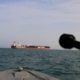 Photo of Iranian Revolutionary Guard pointing weapon at British warship