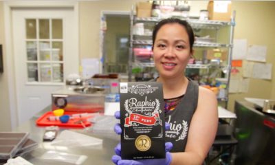 Owner of Raphio Chocolate Factory holds up a bag of chocolate