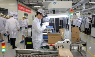 Photo of a staff member works on a mobile phone production line