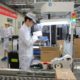 Photo of a staff member works on a mobile phone production line