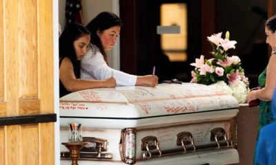 Photo of mourners writing on Keyla Salazar's casket during her funeral