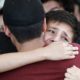 Photo of youths comforting each other at a funeral
