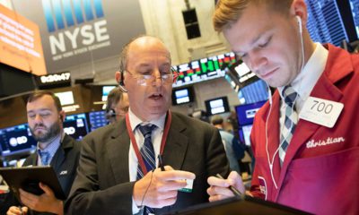 Photo of Gordon Charlop, center, and Christian Bader working at the New York Stock Exchange