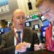 Photo of Gordon Charlop, center, and Christian Bader working at the New York Stock Exchange