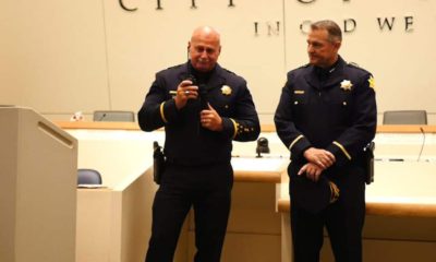 Photo of Jerry Dyer signing off as Fresno Police Chief. He is accompanied by new police chief Andy Hall