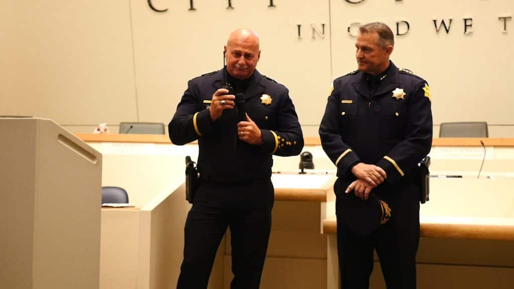 Photo of Jerry Dyer signing off as Fresno Police Chief. He is accompanied by new police chief Andy Hall