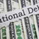 Photo of money and "national debt" on a ripped piece of paper