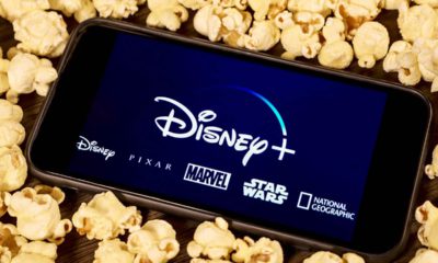 Photo of an iPhone with Disney Plus on the screen surrounded by popcorn
