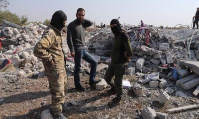 Photo of people looking at destroyed houses