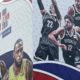 Photo of a worker taking down a billboard advertising an NBA preseason basketball game