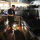 Photo of Salvador Espinosa sweeps in the kitchen of Mary's Pizza Shack