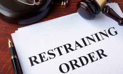 Photo of a restraining order on a desk with a gavel