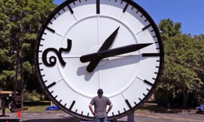 Photo of a man looking up at a big clock