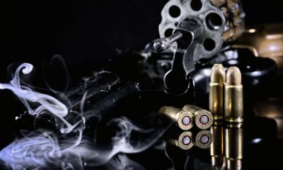 Photo of a Colt revolver, cartridges and smoke