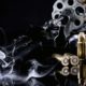 Photo of a Colt revolver, cartridges and smoke