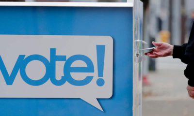 Photo of a voter and a ballot box in Seattle