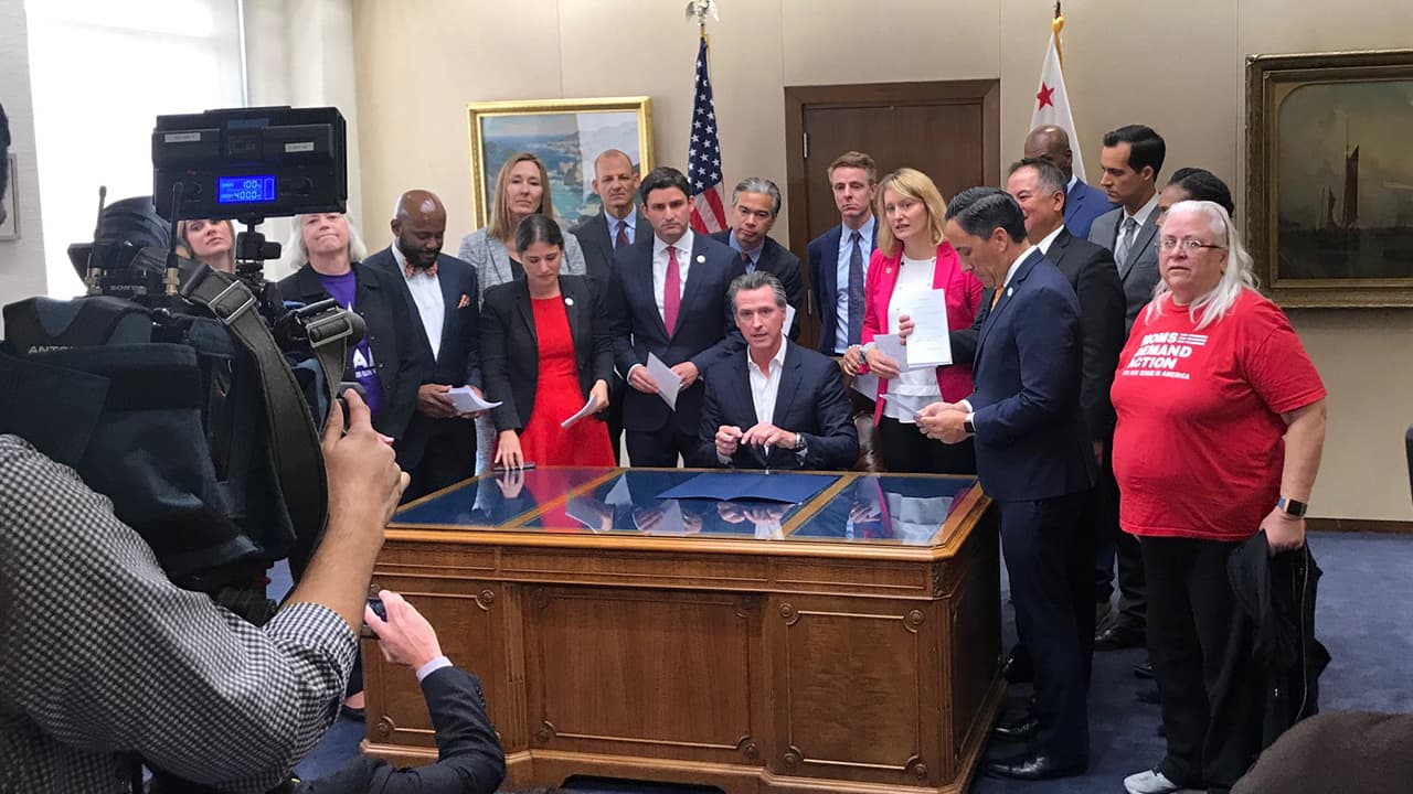 Photo of Gov. Gavin Newsom flanked by legislators and gun control advocates