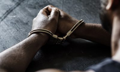 Photo of a man in handcuffs sitting at a table