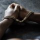 Photo of a man in handcuffs sitting at a table