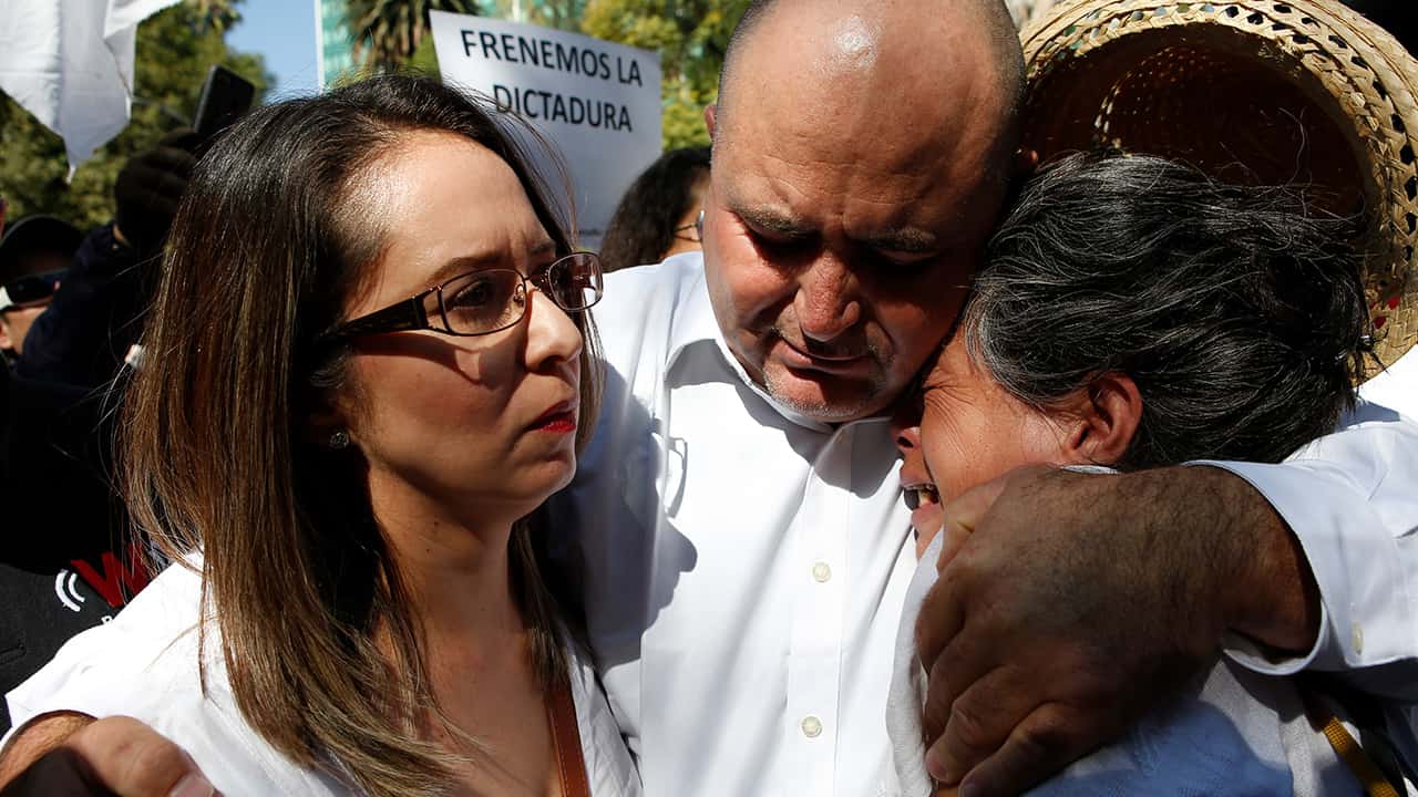 Photo of Julian LeBaron embracing two women before a protest