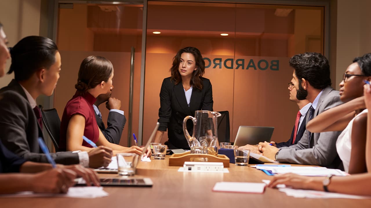 Photo of a women executive leading a board meeting