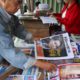 Photo of a man looking through newspapers