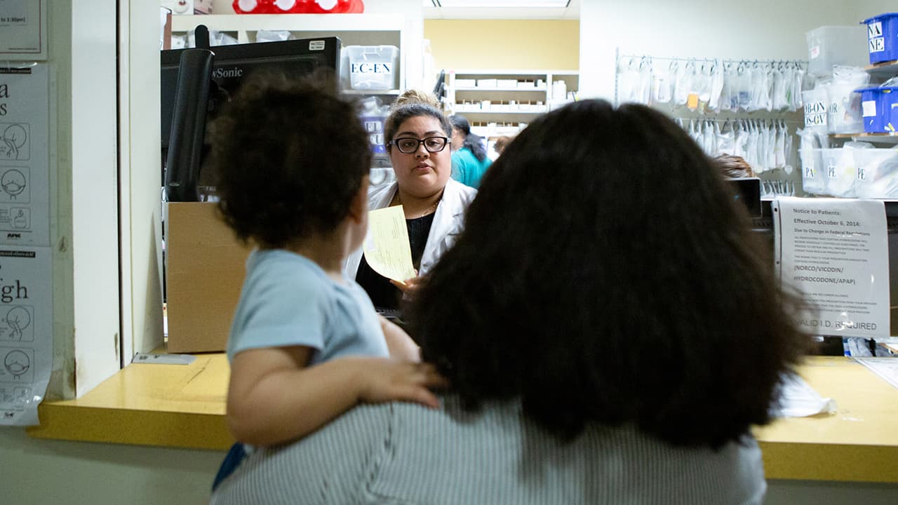 Photo of a family standing in line at a pharmacy