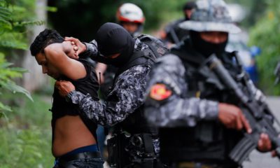 Photo of police frisking a man in El Salvador