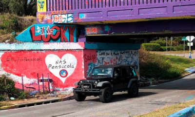 Photo of a vehicle driving by a tribute to the victims of the Naval Air Station Pensacola