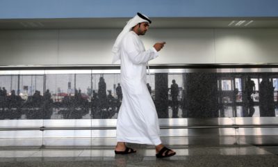 Photo of a worker looking at his phone at the airport in Dubai