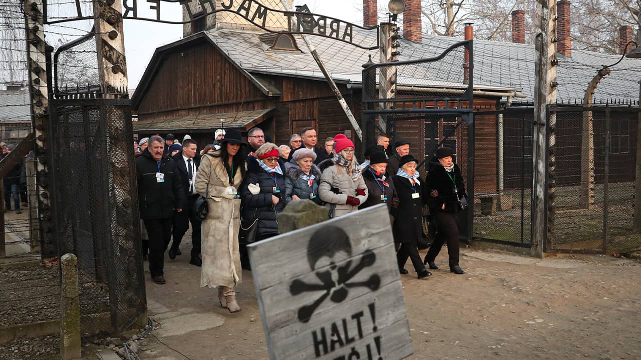 Poland's President Andrzej Duda walking along with survivors through the gates of the Auschwitz Nazi concentration camp to attend the 75th anniversary of its liberation