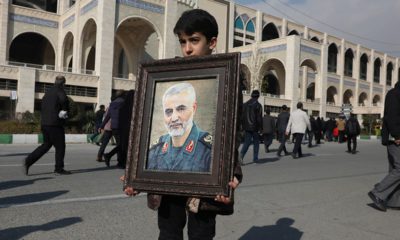 Photo of a boy holding a portrait of Iranian Revolutionary Guard Gen. Qassem Soleimani, who was killed in the U.S. airstrike in Iraq