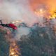 Photo of a helicopter and wildfires burning in Australia