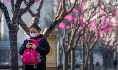 Photo of a woman wearing a face mask as she walks in Beijing