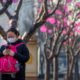 Photo of a woman wearing a face mask as she walks in Beijing