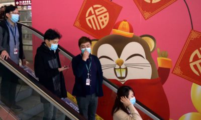 Photo of people wearing face masks as they ride an escalator in China