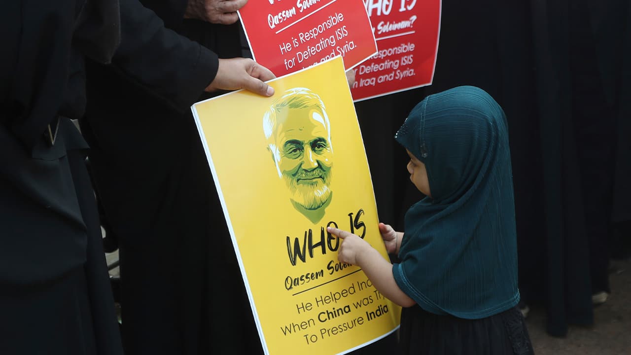 Photo of an Indian Shiite Muslim girl points at a portrait of Iranian Gen. Qassem Soleimani