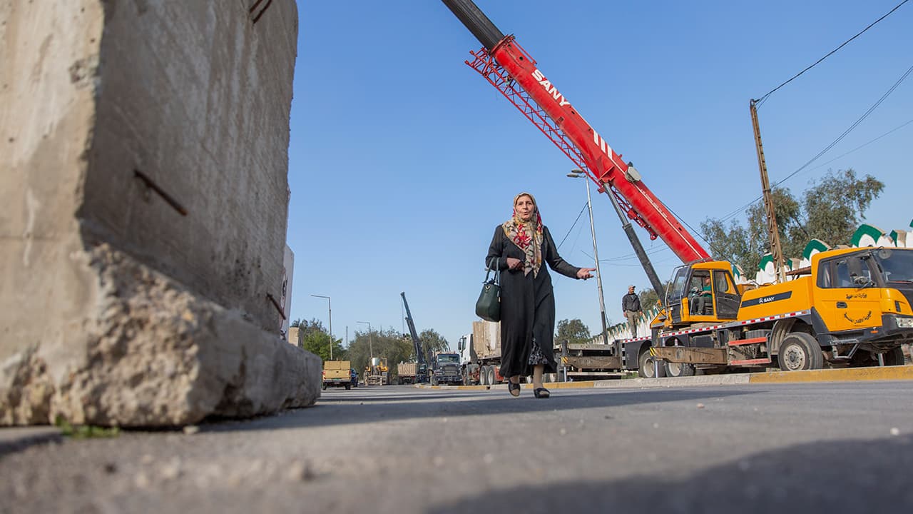 Photo of a woman passing by Iraqi security forces