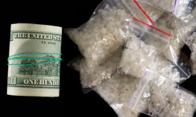 Photo of a roll of money and dime bags of meth