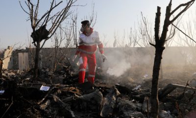 Photo of a rescue worker searching the scene where a Ukrainian plan crashed