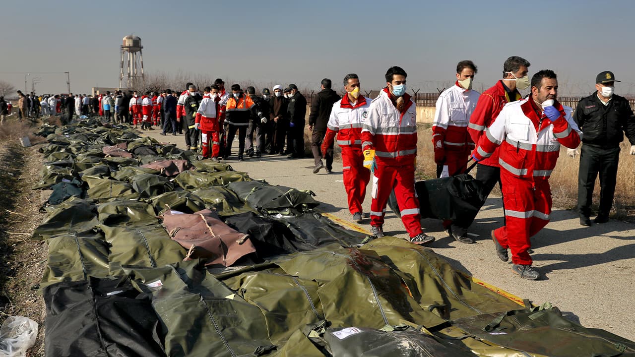 Photo of rescue workers carrying the body of a victim of a Ukrainian plane crash in Shahedshahr