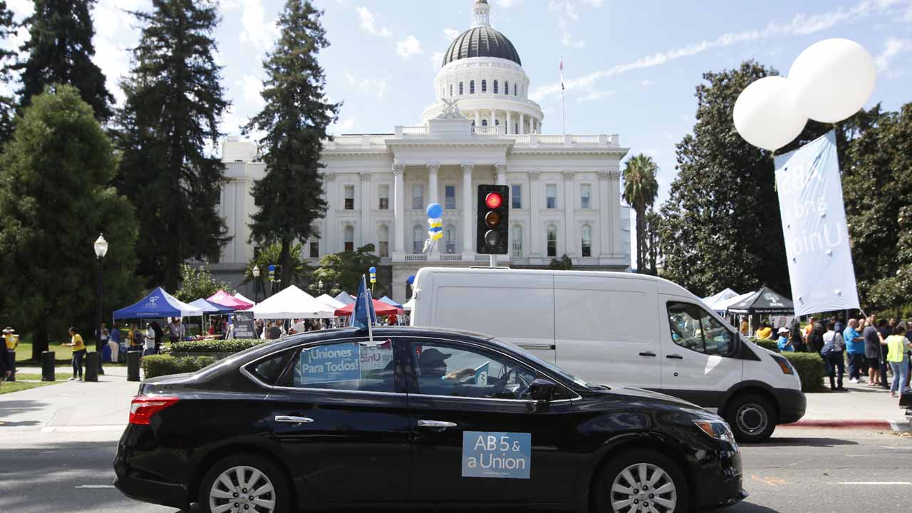 Photo of a car with banners supporting AB 5, the California law reclassifying independent contractors