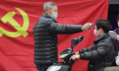 Photo of a volunteer taking the temperature of a scooter driver