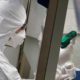 Photo of a French lab scientist in hazmat gear