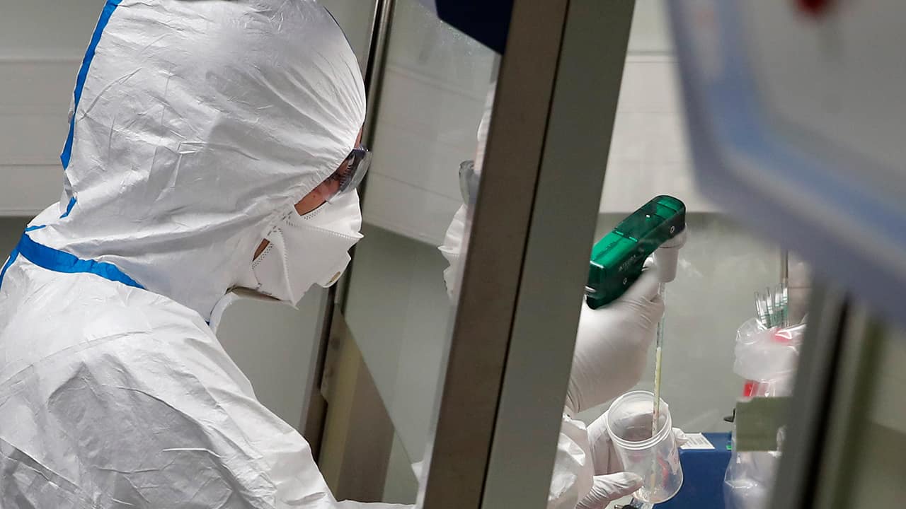 Photo of a French lab scientist in hazmat gear