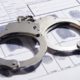 Photo of handcuffs on top of a fingerprint record