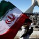 Photo of a boy carrying an Iranian flag