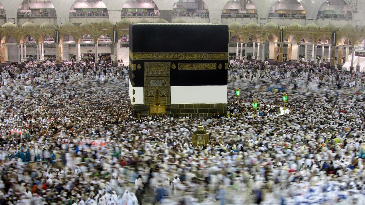 Photo of Muslim pilgrams walking around the Kabaa
