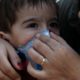 Photo of a woman helping a boy put on a protective face mask in Tehran, Iran